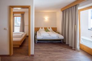a hotel room with a bed and a window at Mountain Living Apartments in San Valentino alla Muta