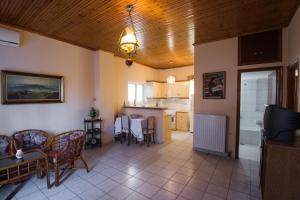 a living room with a table and chairs and a kitchen at Kardiakafti Village in Gastoúni