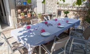 uma mesa azul com rosas cor-de-rosa em cima em La Belle Minervoise em Saint-Frichoux