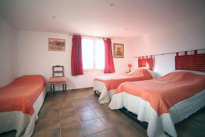 sypialnia z 2 łóżkami i krzesłem w obiekcie B&B Le clos des vignes Saint Raphael w miejscowości Saint-Raphaël