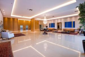 Hotel Araucaria Flat في أراراكارا: غرفة معيشة كبيرة مع أرضية بيضاء كبيرة