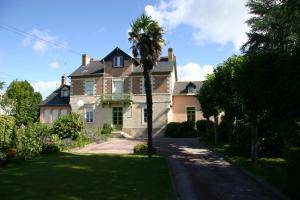 a palm tree in front of a house at Studio du Chalet de Caharet in Pipriac