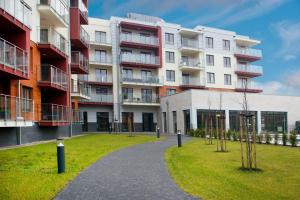 an apartment building with a park in front of it at AquaBaltic in Kołobrzeg