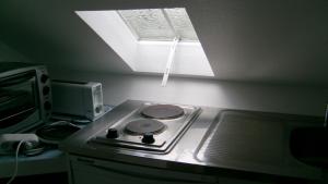 a kitchen with a stove top with a window at Studio du Chalet de Caharet in Pipriac