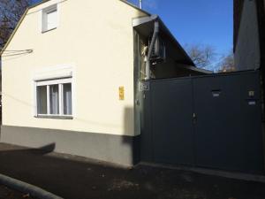 a white house with a gate and a window at Yellow Apartment in Debrecen