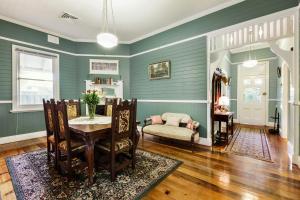 uma sala de estar com paredes verdes e uma mesa e cadeiras em ‘Tara-Lee’ em Cessnock