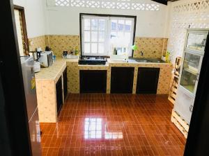 a kitchen with a tile floor and counters and a window at Winter House Chiang Rai in Chiang Rai