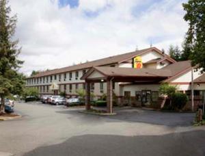 a hotel building with cars parked in a parking lot at Super 8 by Wyndham Lacey Olympia Area in Lacey