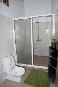 a bathroom with a white toilet and a shower at Shamba Lodge in Nungwi