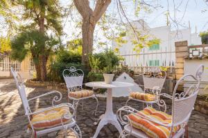 a white table and chairs in a yard with a tree at Villa Cactus in Port d'Alcudia