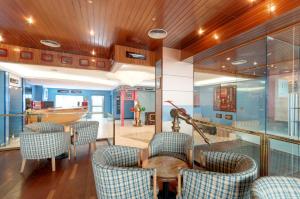 a room with chairs and a table and a boat at Hotel Náyade in Los Ángeles de San Rafael