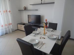 a dining room with a table with chairs and a television at Apartments Ante in Senj