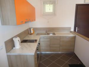 a small kitchen with wooden cabinets and a sink at Apartments Ante in Senj +14 photos