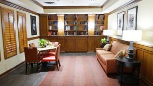 sala de estar con sofá, mesa y biblioteca en Extended Stay America Suites - Dallas - Richardson, en Richardson
