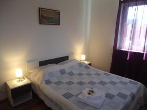 sypialnia z łóżkiem z 2 stolikami nocnymi i 2 lampami w obiekcie Apartments Ante w mieście Senj