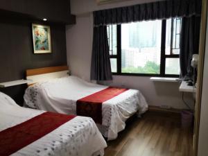 ein Hotelzimmer mit 2 Betten und einem Fenster in der Unterkunft Hong Kong Tai San Guest House (Burlington Branch) in Hongkong