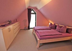 フェルトベルクにあるFerienhaus Feldberg SEE 9421のピンクの壁のベッドルーム1室、紫のシーツが備わるベッド1台