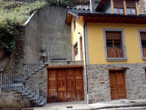 a building with two doors and stairs in front at Casa Rural Las Mestas in Cangas del Narcea