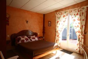 een slaapkamer met een bed en een raam met gordijnen bij L'ECHELLE in La Plaine des Palmistes