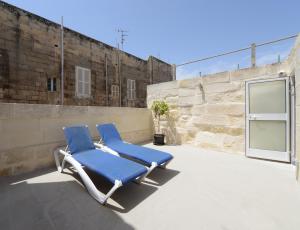 two blue lounge chairs sitting on a patio at Lovely House Private Rooms by Vallettastay in Valletta