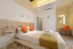a bedroom with a large bed with orange pillows at Vallettastay Lovely House Private Rooms in Valletta