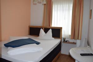 - une chambre avec un lit doté de draps et d'oreillers blancs dans l'établissement Alpengasthof Eichtbauer, à Spital am Semmering