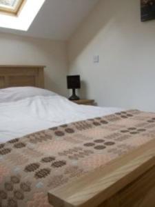 LlandysulにあるRock Mill Apartmentのベッドルーム1室(ベッド1台、テーブルの上にランプ付)