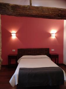 a bedroom with a bed with two lights on the wall at La Posada de Pesquera in Pesquera de Duero