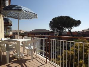 a balcony with a table and chairs and an umbrella at Gilda Vacanze Metro Battistini in Rome