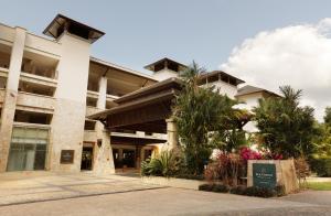 um edifício com palmeiras em frente em Pullman Palm Cove Sea Temple Resort & Spa em Palm Cove