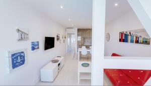 - un salon avec des murs blancs et un canapé rouge dans l'établissement Stay Inn Albufeira - 303B Apartment, à Albufeira