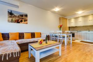 a living room with a couch and a table at Piano Apartments Delta City in Podgorica