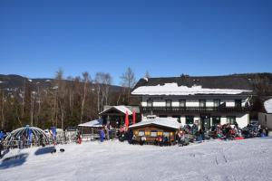 a ski lodge with a crowd of people in the snow at Alpengasthof Eichtbauer in Spital am Semmering