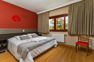 Un dormitorio con una cama grande y una pared roja. en Matsubara Pousada, en Campos do Jordão 62 fotos más