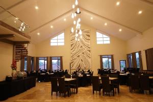 un salón de banquetes con mesas y sillas y una lámpara de araña en Grand Harvest Resort & Villas, en Banyuwangi