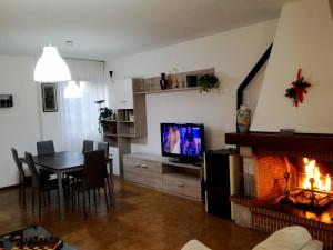 a living room with a fireplace and a table and a television at Casa Alessandro in Città di Castello