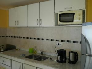a kitchen with a sink and a microwave at La Rinconada in Las Grutas