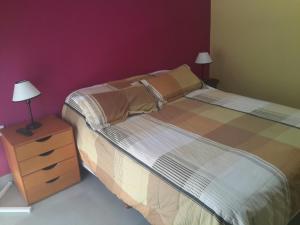 a bedroom with a bed and a nightstand with two lamps at La Rinconada in Las Grutas