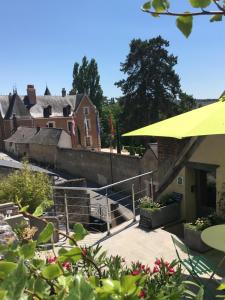 a group of buildings with stairs and a yellow umbrella at Le Balcon De Leonard in Amboise