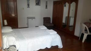 a bedroom with a white bed in a room at Hostal Camiluz in Nazca