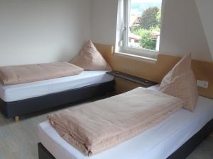 two beds in a room with a window at Wein- Appartements Borth in Bretzfeld