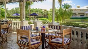 a patio with a table and chairs and a pool at Inn at Pelican Bay in Naples