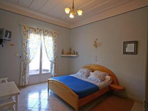 een slaapkamer met een bed met blauwe lakens en een raam bij L'ECHELLE in La Plaine des Palmistes