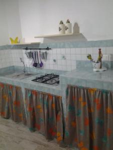 a kitchen with a counter with a sink and a stove at Le casette di Simona in Lampedusa