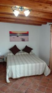 a bedroom with a white bed with a ceiling at Le casette di Simona in Lampedusa