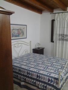una camera con un letto e un piumone blu e bianco di Le casette di Simona a Lampedusa