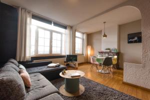 a living room with a couch and a table at La petite Naimette in Liège