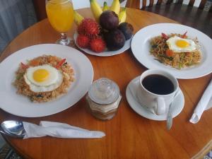 uma mesa com pratos de comida e uma chávena de café em Aris Homestay and Warung Made em Munduk