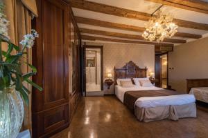 a bedroom with a bed and a chandelier at Palazzo Bembo - Exclusive Accommodation in Venice