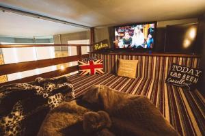 a room with a television and a bed with a blanket at Brooklyn lodge in Margate